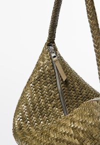 Olivengrøn håndvævet lædertaske med fletet rem og en sølvlynlås med en matchende lædertrækker.