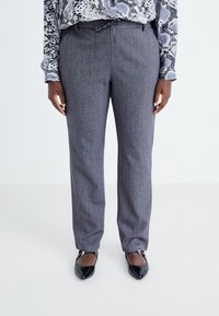 Grå strukturerade byxor med rak passform, dragsko i midjan och subtilt mönster. Matchas med svarta spetsiga ballerinas.