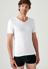 White short-sleeve V-neck T-shirt made of lightweight fabric, fitted design, with a smooth texture and subtle stretch.