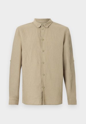 Chemise beige à manches longues avec col classique et pattes de manches pour retrousser les manches.