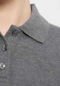 Γκρι πλεκτό πόλο πουκάμισο με γιακά, διαθέτει πατιλέτα με δύο σκούρα κουμπιά και ριμπ υφή.