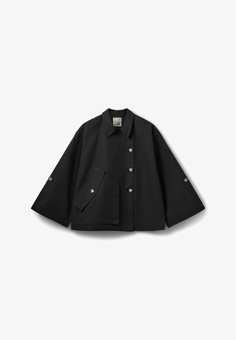 Veste courte noire en tissu lisse, avec un col large, des manches surdimensionnées, une poche avant et des boutons métalliques en accent.