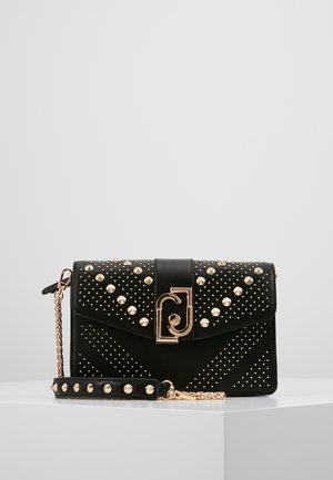 Czarna skórzana kopertówka z złotymi ćwiekami, geometrycznymi wzorami, złotym łańcuszkiem oraz centralnym złotym zapięciem z dekoracyjnym wzorem.