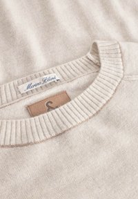 Beige Merino-Mischpullover mit geripptem Kragen. Verfügt über ein Lederetikett mit dem Markennamen und zeigt einen weichen, texturierten Stoff.