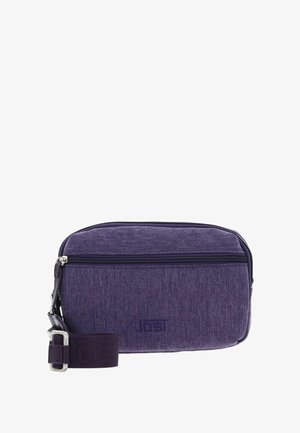 Sac bandoulière rectangulaire violet avec poche zippée à l'avant, bandoulière réglable et logo de marque subtilement embossé sur la texture du tissu.