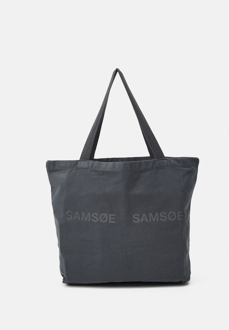 Canvas totebag i mørkegrå med to robuste håndtak og subtilt trykket merkenavn "SAM SøE" på forsiden. Enkelt design, myk tekstur.