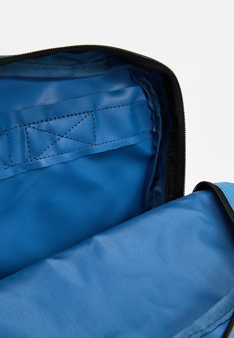 Bolsa azul con cremallera, con un interior de textura suave, que cuenta con una cremallera negra y un bolsillo interior. Material duradero, forma rectangular.