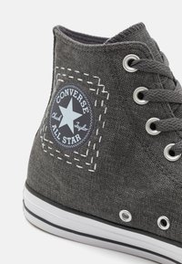 Sivi platneni visoki tenisice s bijelim gumenim đonom, metalnim rupicama i plavim okruglim logotipom s zvijezdom i bijelim detaljima šivanja.