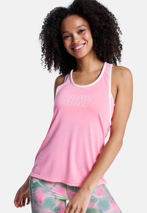 Roze mouwloze tanktop met een witte rand en een gedurfde "ROXY"-logo. De stof lijkt zacht; gecombineerd met kleurrijke, patroonleggings.