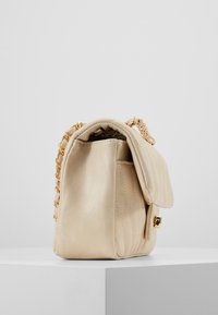 Beige Lederhandtasche mit gestepptem Design, goldener Kettenriemen und Klappenverschluss. Glatte Textur und rechteckige Form.