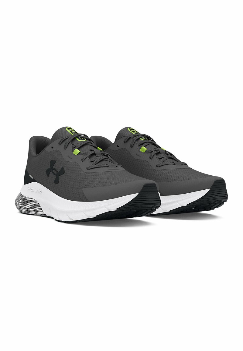 Scarpe da ginnastica grigie con suola nera e bianca. Presentano una parte superiore testurizzata, dettagli verdi e un logo distintivo sul lato. Design leggero.