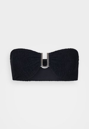 Bandeau noir en tissu texturé, avec un accent métallique central et des bords lisses, conçu pour un maintien sécurisé sans bretelles.