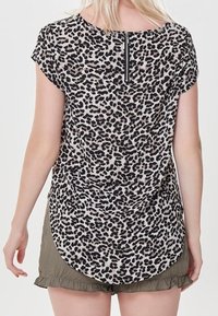 Top leopard print con maniche corte, orlo rotondo e una zipper nera sul retro. Il tessuto appare leggero con una texture morbida.