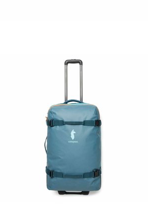Blue wheeled suitcase with telescoping handle and two compression straps, featuring a white llama logo and the text "cotopaxi" on front.