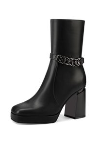 Stivale in pelle nera alla caviglia con un tacco quadrato spesso, adornato con un dettaglio in catena metallica attorno alla caviglia e suola piattaforma.