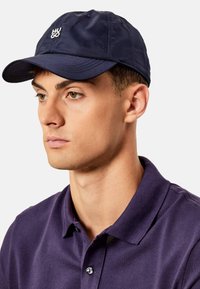 Gorra de béisbol Navy con logo bordado "HUGO", hecha de tela ligera, con visera curvada y ojales de ventilación.