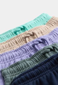 Pila de cinco cinturillas con cordón acanaladas en colores verde menta, beige, lavanda, verde salvia y azul marino.