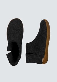 Schwarze Filz-Stiefeletten mit strukturierten Oberflächen, offenen Seiten und einer Gummisohle. Die Sohle verfügt über ein gemustertes Profil für besseren Halt.