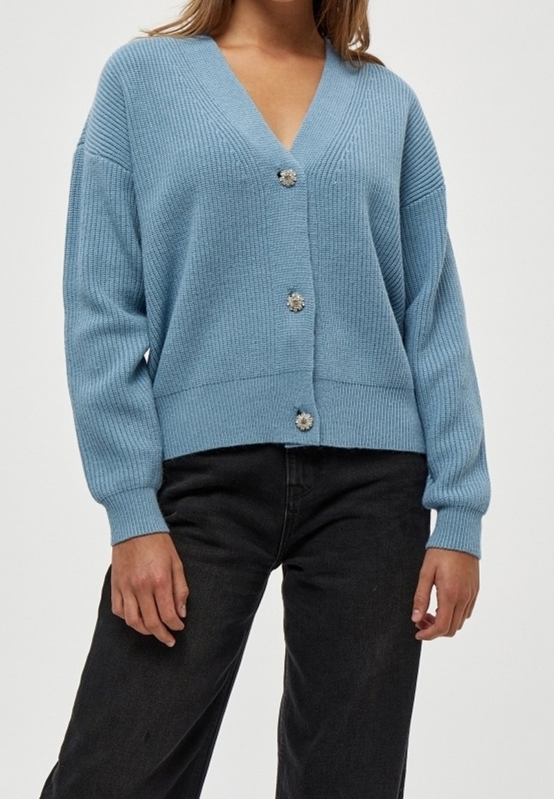 Cardigan lavorato a maglia azzurro chiaro con scollo a V, maniche lunghe e texture a coste. Presenta tre bottoni decorativi sul davanti.