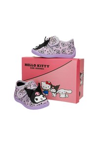Chaussures d'enfant violettes avec des visages et des motifs de personnages de dessins animés noirs, présentées sur une boîte rose Hello Kitty et Friends avec des illustrations de personnages.