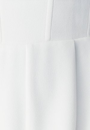 Witte textuur stof met subtiele lijnen en secties, met een zachte, matte afwerking. Het geplooide ontwerp accentueert de gelaagde uitstraling.