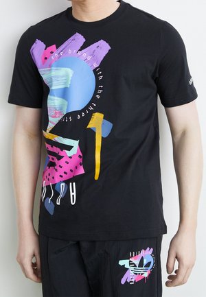 Schwarzes Baumwoll-T-Shirt mit abstraktem, mehrfarbigem Grafikdesign, einschließlich blauer, rosa, violetter und gelber Akzente. Kurzärmlig, Rundhalsausschnitt.