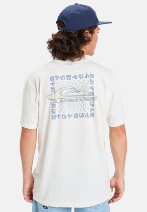 Camiseta de manga corta blanca con un gráfico azul en la parte de atrás, que muestra un diseño de olas y varios patrones. La tela parece suave y ligera.