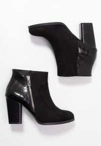 Sorte ankelstøvler med overdel af ruskind og krokodilleprægede sidestykker, med en lynlås i siden og en solid blokhæl.