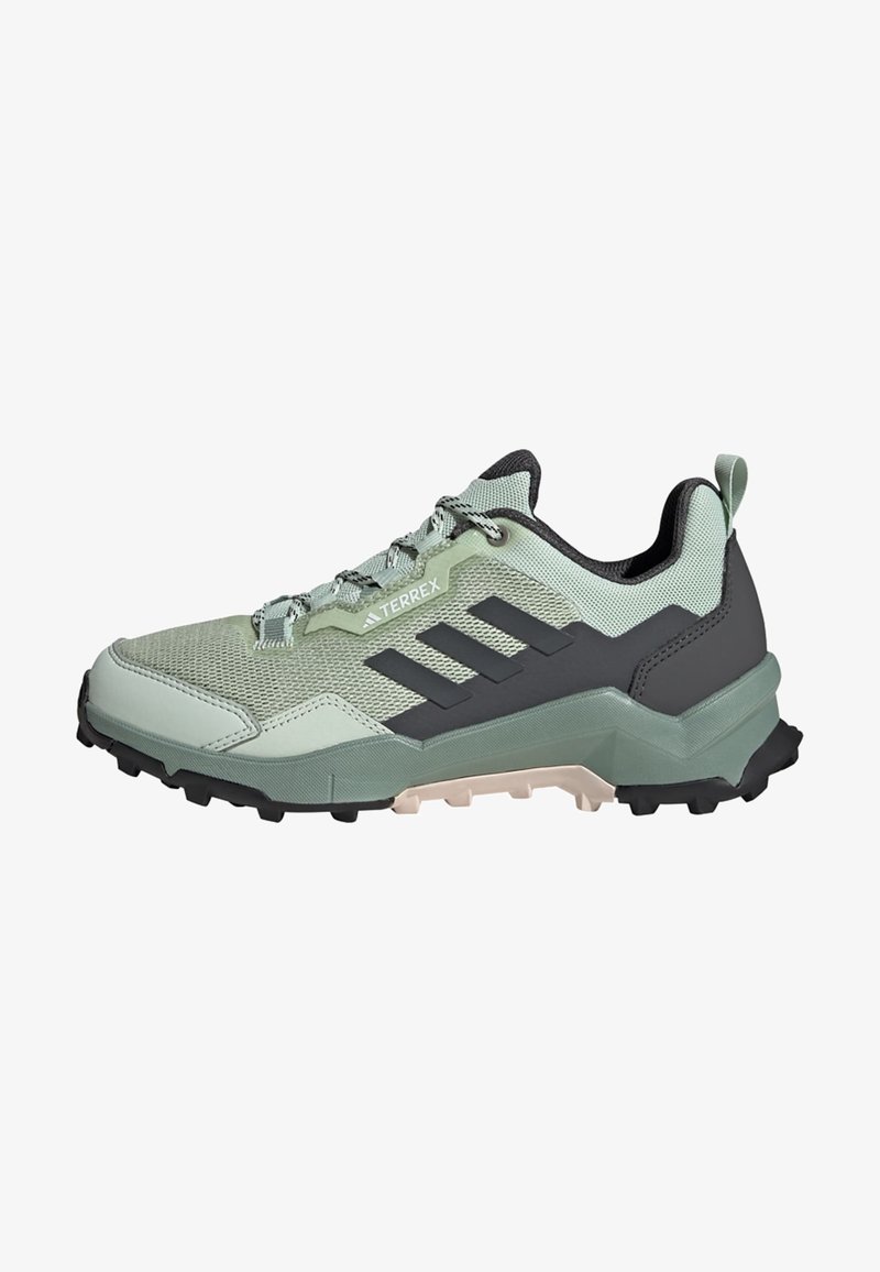 Zapatillas deportivas verde claro con una parte superior de malla texturizada, acentos negros, tres rayas paralelas y una suela robusta diseñada para tracción al aire libre.