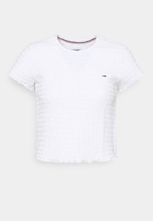 Crop top texturé blanc à manches courtes avec petit logo Tommy Hilfiger sur la poitrine et encolure ronde côtelée avec bordure rouge, blanche et bleue.