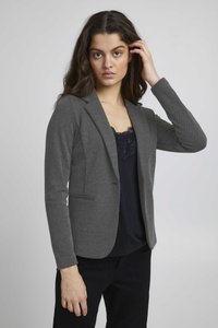 Blazer gris ajustado con un acabado texturizado, cierre de un botón y dos bolsillos laterales, llevado sobre una blusa negra con dobladillo de encaje.