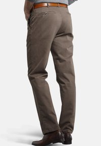 Braune Baumwollhosen mit geradem Bein, ausgestattet mit Gesäßtaschen und einem braunen Ledergürtel. Passen perfekt zu schwarzen Lederschuhen.
