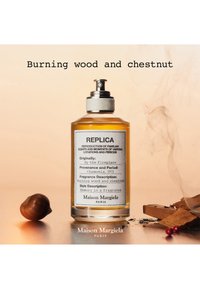 Maison Margiela Replica parfumflesje met het label Brandend hout en kastanje met kastanje- en houtstukken op een beige achtergrond.