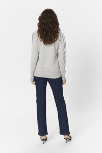 Maglione grigio chiaro con polsini e orlo a coste, abbinato a jeans dritti blu scuro. Il modello è visto di spalle.