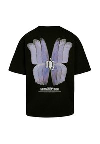Sort bomulds T-shirt med et stort lilla sommerfugletryk på ryggen, med tekst nedenunder der står "METAMORFOSES HISTORIE."