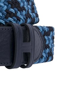 Cinturón de tela tejido en azul y negro con un panel de cuero liso oscuro y una hebilla texturizada que presenta un diseño cuadrado y detalle de logo.