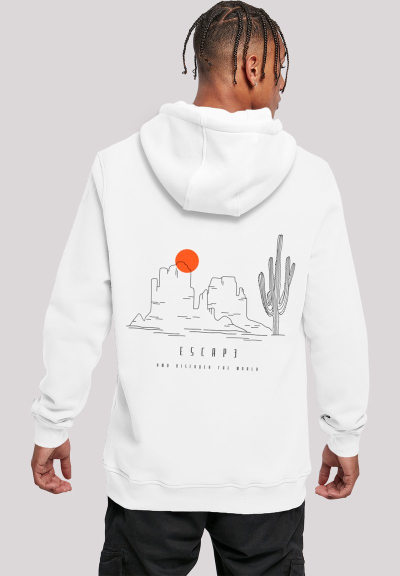Weiße Kapuzenjacke mit einem grafischen Design von Bergen, einer Sonne und einem Kaktus. Der Text lautet "FLIEHE UND ENTDECKE DIE WELT." Weicher Stoff mit lockerer Passform.
