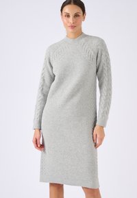 Abito lavorato a maglia grigio chiaro con texture a costine e dettagli a trecce sulle maniche e sul colletto rotondo. Design di lunghezza media.