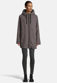 Hooded, oversized jacket in textured dark gray fabric with a full front zipper and contrasting black drawstring accents.