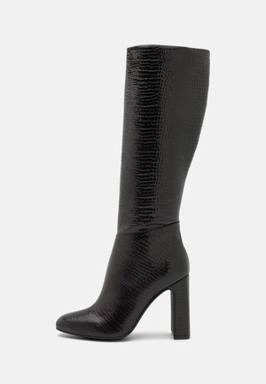 Bottes noires montantes en peau de crocodile, avec un bout pointu et un talon épais. Fini lisse avec un design élégant, adaptées à une tenue formelle ou décontractée.