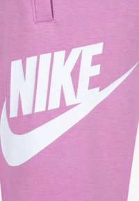 Ροζ βαμβακερές φόρμες, με μεγάλο λευκό λογότυπο "NIKE" και σχέδιο swoosh, με απαλή υφή και κλασική εφαρμογή.