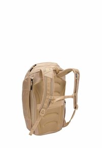 Sac à dos beige avec dos rembourré, accents en maille, doubles zips supérieurs et bretelles ajustables. Dispose de plusieurs poches latérales pour le rangement.