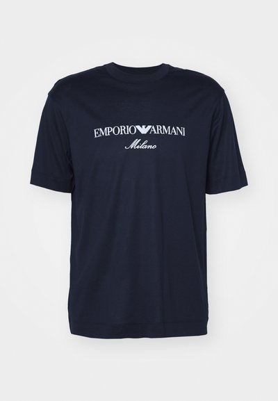 Μπλέ ναυτικό βαμβακερό μπλουζάκι με κοντά μανίκια. Διαθέτει λευκό κεντημένο λογότυπο «EMPORIO ARMANI Milano» στο στήθος.