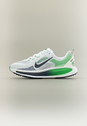 Λευκό και πράσινο παπούτσι για τρέξιμο Nike με μαύρο λογότυπο Swoosh, αναπνεύσιμο πλέγμα στο επάνω μέρος και παχιά, μαξιλαρωμένη σόλα με επισήμανση "react x".