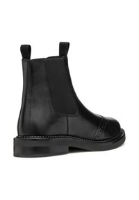 Stivale Chelsea in pelle nera con pannelli laterali elasticizzati, punta rotonda, dettagli brogue e una suola spessa con bordo cucito.