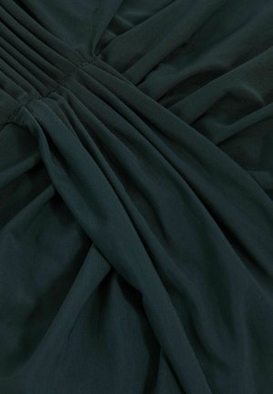 Tissu vert foncé à tissage texturé, avec des plis froncés et un drapé lisse. La surface présente une apparence douce et légère.