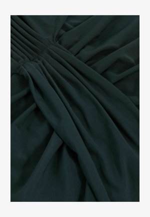Tmavo zelená tkanina s textúrovanou väzbou, s vy gathered plisovaním a hladkým drapovaním. Povrch vykazuje mäkký a ľahký vzhľad.