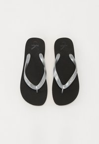 Svarte flip-flops med en glatt matte såle, sølvfargede gummistropper og "Calvin Klein Jeans" merkevare på en stropp.