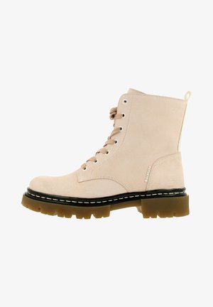 Stivaletto in camoscio beige chiaro con lacci, suola in gomma spessa marrone con tasselli e bordo nero, linguetta laterale e occhielli metallici.