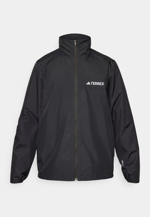Veste imperméable noire avec un col haut et une fermeture éclair complète. Présente le logo "TERREX" en blanc sur la poitrine gauche, des poignets élastiques et une coupe ample.